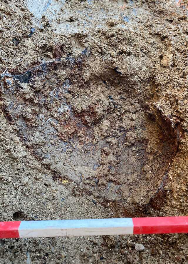 Close-up excavation shot highlighting the helmet’s intricate details.