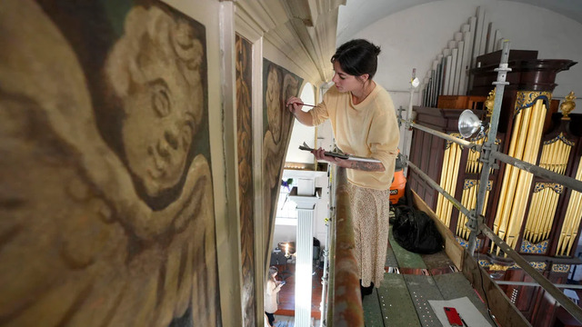 Conservator Corrine Long, from Dover, N.H., meticulously restores nearly 300-year-old painted angels on the walls of Old North Church, December 18, 2024, in Boston.