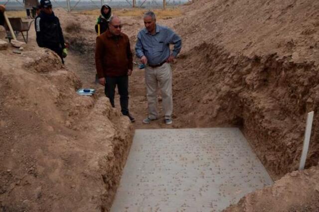 Dr. Ali A. Yassin al-Jabouri and Representative Fadhel Mohamad examine a recently unearthed inscribed door sill from the palace of Assyrian King Adad-Nirari III (811–783 BCE) at Nimrud. (Credit: Michael Danti)