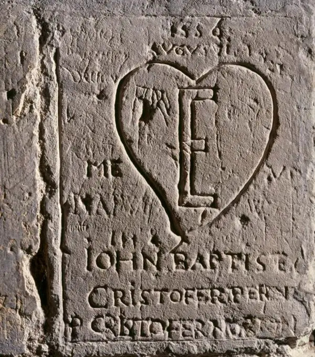 Inside the Salt Tower, the letter “E” in a heart represents Queen Elizabeth in graffiti attributed to her Italian tutor, Giovanni Battista Castiglione.