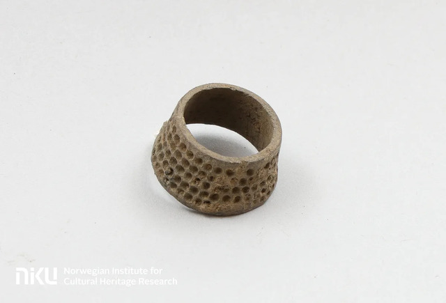 Made of copper alloy, this thimble suggests that sewing was a common activity within the building, revealing insights into everyday life.