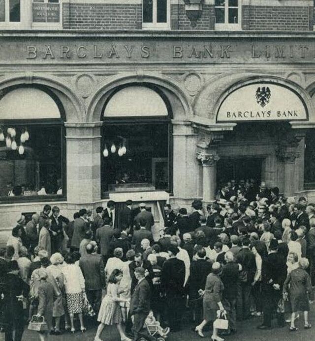 Onlookers gather eagerly to catch a glimpse of the groundbreaking cash machine.