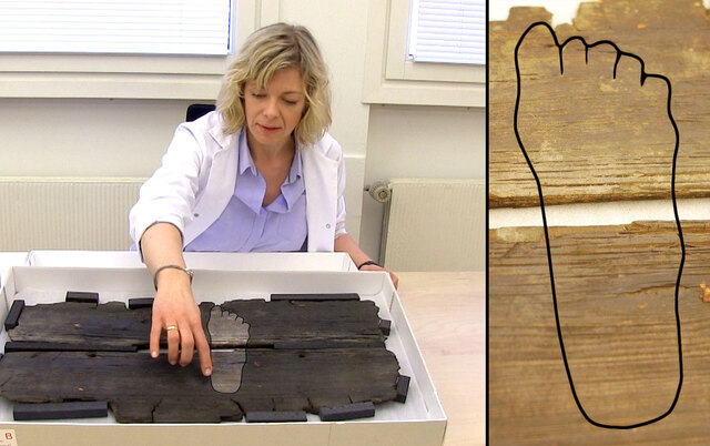 Researcher examining the Viking foot carving on a Gokstad Ship plank, providing insight into the daily lives of Viking crew members.