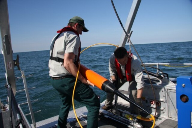 Researchers handling a side-scan sonar towfish, a key tool for capturing detailed images of the shipwrecks’ condition.