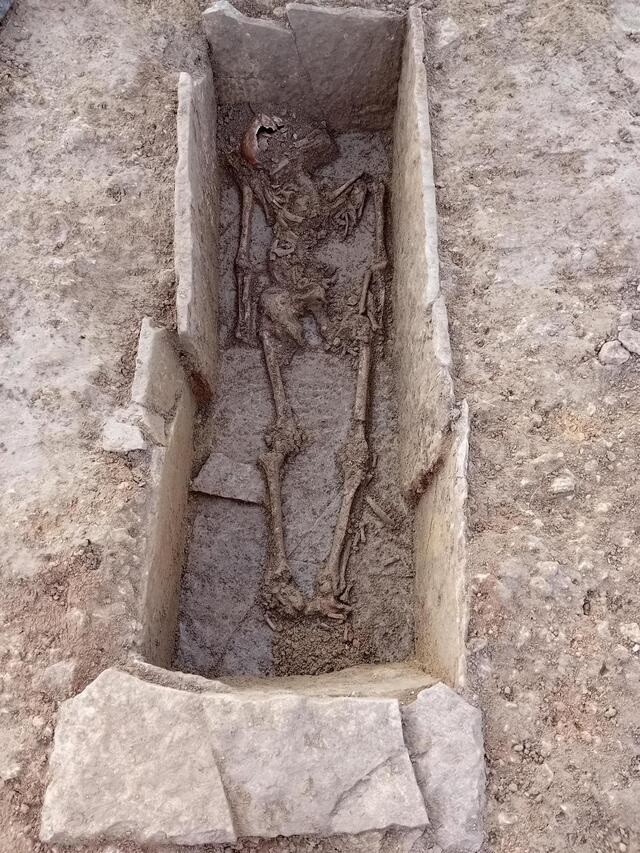 The skeletal remains inside the Roman stone coffin discovered during the A47 roadworks in Cambridgeshire. The limestone sarcophagus, dating back over 1,500 years, provides a glimpse into Roman funerary practices.