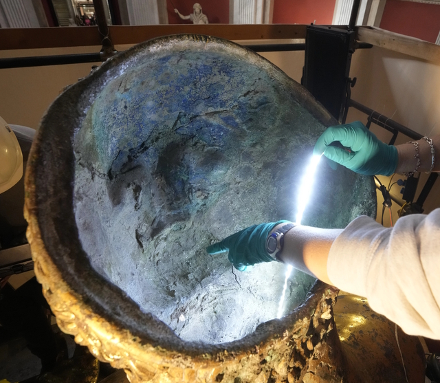 The interior structure of the Hercules statue is carefully inspected under light for further insights into its construction and preservation.