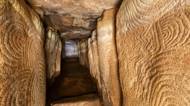 The passage leading through the Gavrinis mound reveals meticulously carved stones, guiding visitors toward the tomb. (Credit: Brittany Tourism)