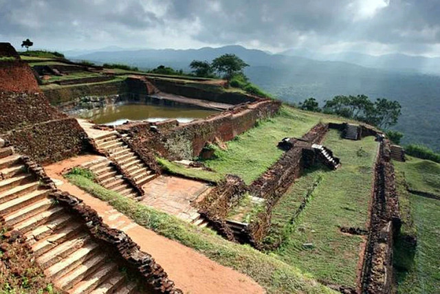 The remains of the palace complex atop Sigiriya, with its meticulously designed terraces and water reservoirs offering panoramic views of the surrounding landscape.