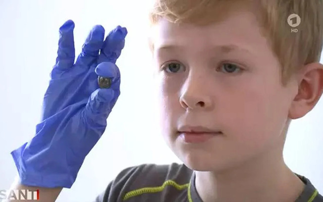 Young Bjarne proudly holds the ancient Roman coin he unearthed while playing in a sandbox at his elementary school. Credit: Brisant.