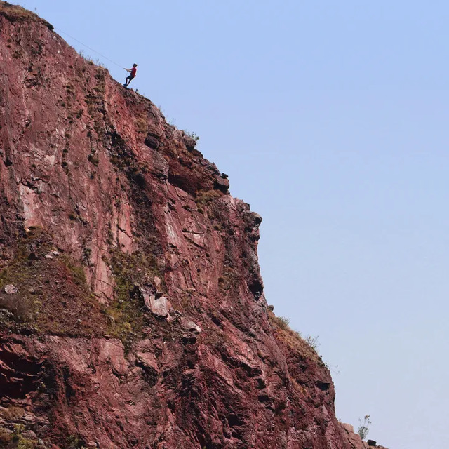 Orr Tidhar, a student at Waterford Kamhlaba College in Eswatini, abseils down Lion Cavern’s cliff face in search of additional ancient mines. He taught excavators how to rappel so they could collect samples from newly discovered sites—two more have been found—otherwise inaccessible from above. (Photo: Bob Forrester)